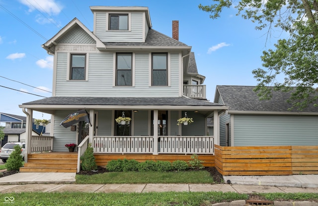 1665 N College Ave, Indianapolis, IN 46202 - view of front facade featuring covered porch, a chimney, a shingled roof, and a balcony