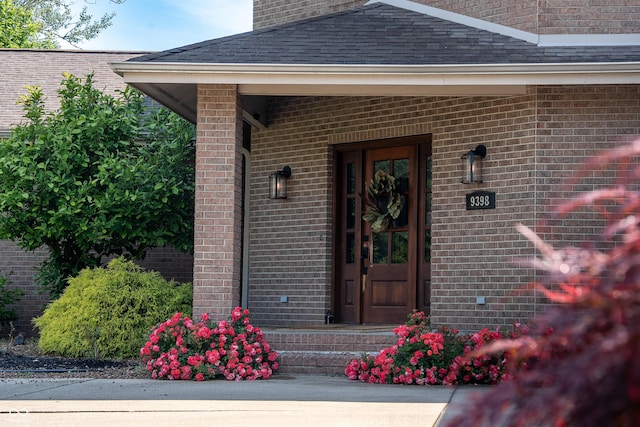 9398 W Mirror Rd, Columbus, IN 47201 - doorway to property featuring brick siding, roof with shingles, and a chimney
