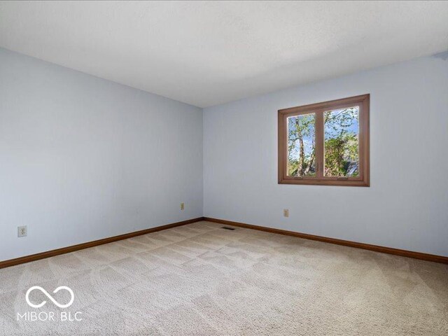unfurnished room with light colored carpet, baseboards, and visible vents