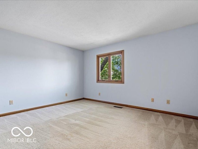 unfurnished room with visible vents, a textured ceiling, baseboards, and light carpet