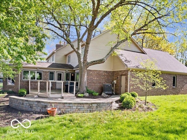 rear view of house with a yard, brick siding, central AC, and a patio