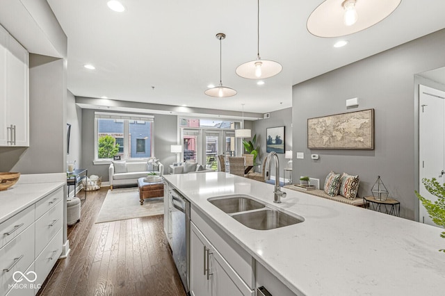 622 E 10th St Unit 206, Indianapolis, IN 46202 - kitchen with a sink, stainless steel dishwasher, open floor plan, white cabinets, and dark wood-type flooring