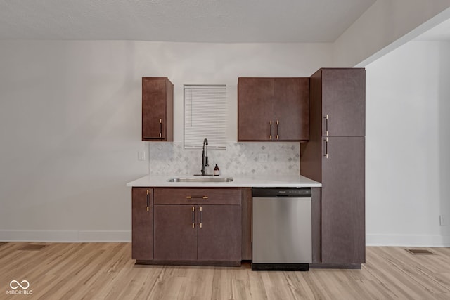 843 N Oxford St, Indianapolis, IN 46201 - kitchen featuring stainless steel dishwasher, light wood-style floors, light countertops, dark brown cabinets, and tasteful backsplash