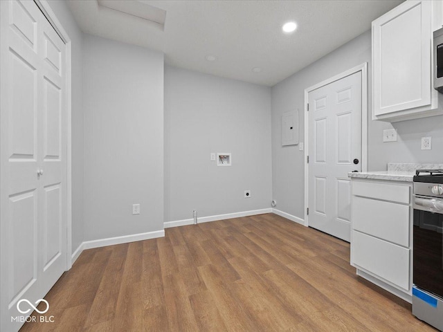 329 Roosevelt Dr, Shelbyville, IN 46176 - kitchen featuring light stone counters, wood finished floors, baseboards, appliances with stainless steel finishes, and white cabinetry