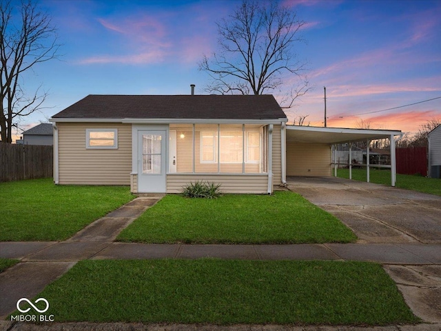 329 Roosevelt Dr, Shelbyville, IN 46176 - view of front facade featuring a carport, concrete driveway, a front yard, and fence