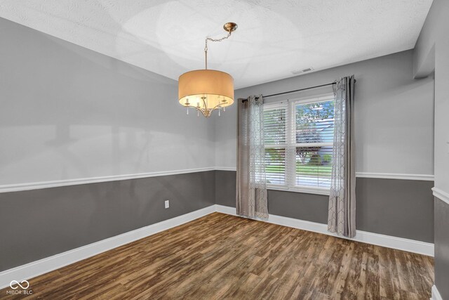 7383 Poppyseed Dr, Indianapolis, IN 46237 - unfurnished room with wood finished floors, a chandelier, baseboards, and a textured ceiling