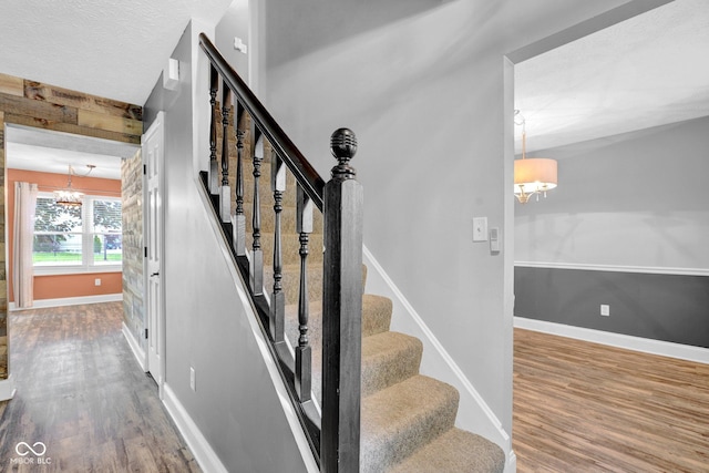 7383 Poppyseed Dr, Indianapolis, IN 46237 - stairway with a chandelier, wood finished floors, baseboards, and a textured ceiling