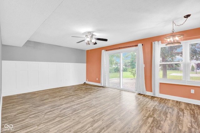 7383 Poppyseed Dr, Indianapolis, IN 46237 - spare room with wood finished floors, a ceiling fan, a chandelier, baseboards, and a textured ceiling