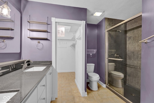7383 Poppyseed Dr, Indianapolis, IN 46237 - full bath featuring toilet, double vanity, a stall shower, tile patterned flooring, and a spacious closet