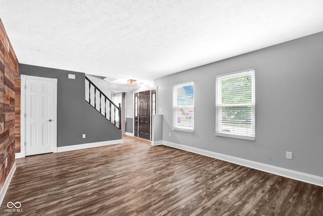 7383 Poppyseed Dr, Indianapolis, IN 46237 - unfurnished living room with wood finished floors, stairs, a textured ceiling, and baseboards