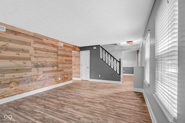 7383 Poppyseed Dr, Indianapolis, IN 46237 - spare room featuring wood walls, stairs, wood finished floors, baseboards, and a textured ceiling