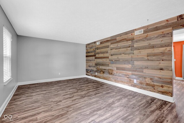 7383 Poppyseed Dr, Indianapolis, IN 46237 - unfurnished room featuring wood walls, wood finished floors, baseboards, and an accent wall