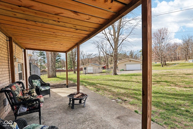 view of patio / terrace with an outdoor structure, an outdoor fire pit, fence, and a garage
