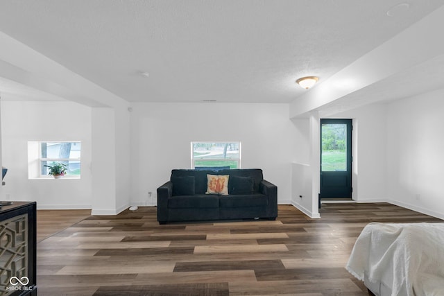 bedroom with baseboards, wood finished floors, and a textured ceiling