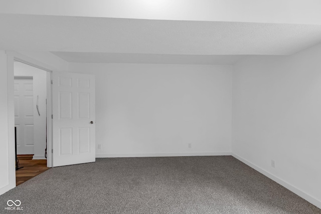 carpeted empty room featuring baseboards