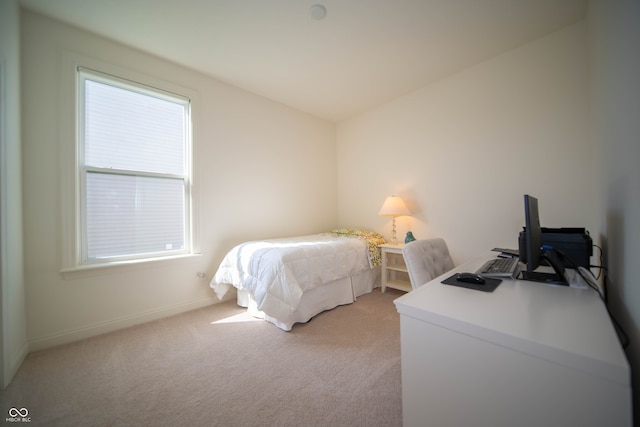 bedroom featuring baseboards and light carpet