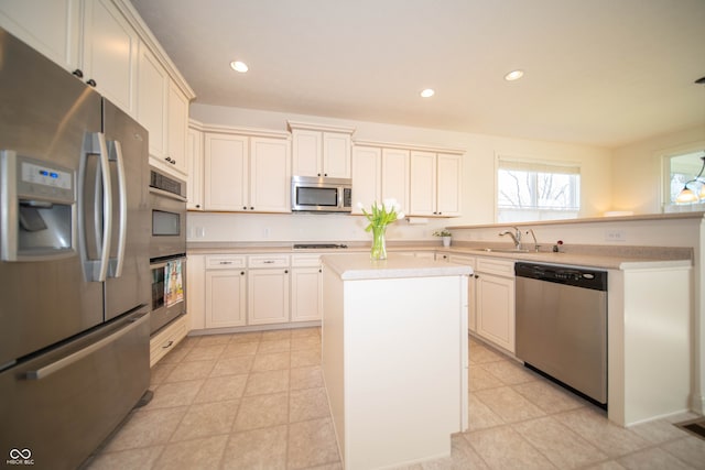 kitchen with a sink, light countertops, stainless steel appliances, recessed lighting, and a kitchen island