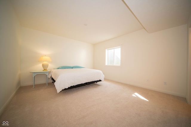 bedroom featuring baseboards and light colored carpet