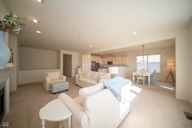 living area featuring a fireplace with flush hearth, light carpet, and recessed lighting