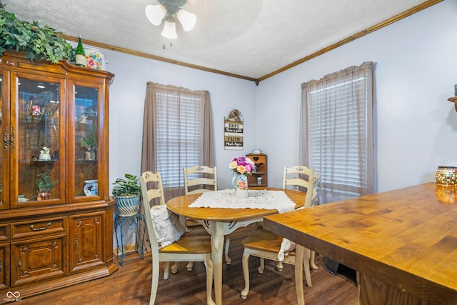 dining room with ornamental molding, a ceiling fan, dark wood-style flooring, and a textured ceiling