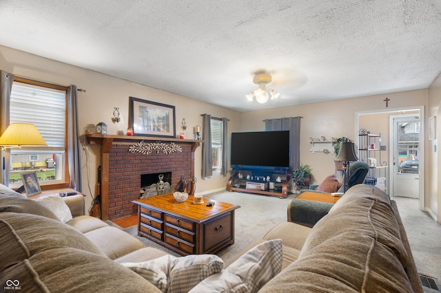 carpeted living area featuring an inviting chandelier, a fireplace, a textured ceiling, and visible vents