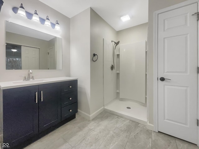 full bathroom featuring vanity, baseboards, and a walk in shower