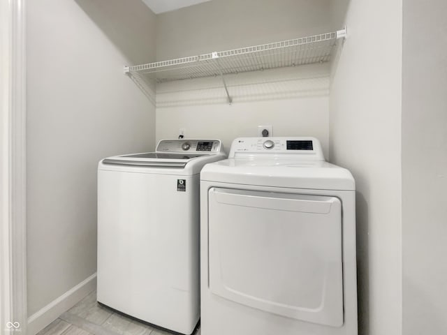 laundry area featuring baseboards, independent washer and dryer, and laundry area