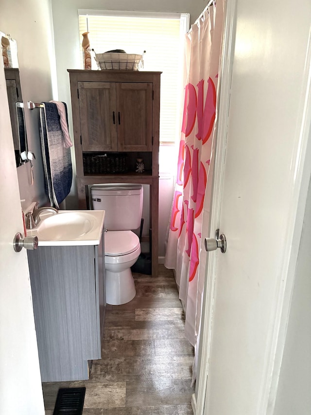5368 Southeastern Ave, Indianapolis, IN 46203 - full bathroom with visible vents, a shower with curtain, toilet, vanity, and wood finished floors