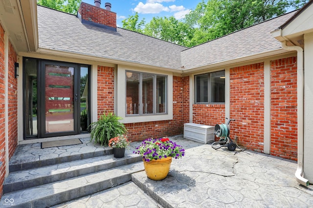 22 Point Ln, Arcadia, IN 46030 - doorway to property featuring roof with shingles, brick siding, and a patio area