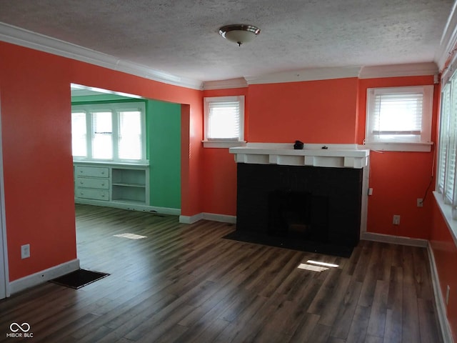 unfurnished living room with a fireplace with flush hearth, baseboards, wood finished floors, and a textured ceiling