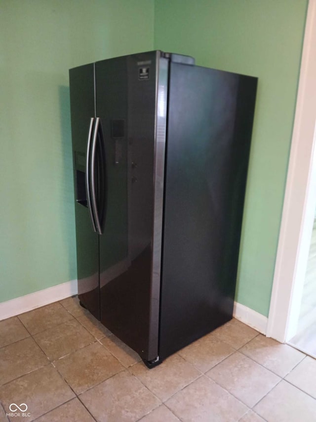 interior details with black fridge with ice dispenser and baseboards