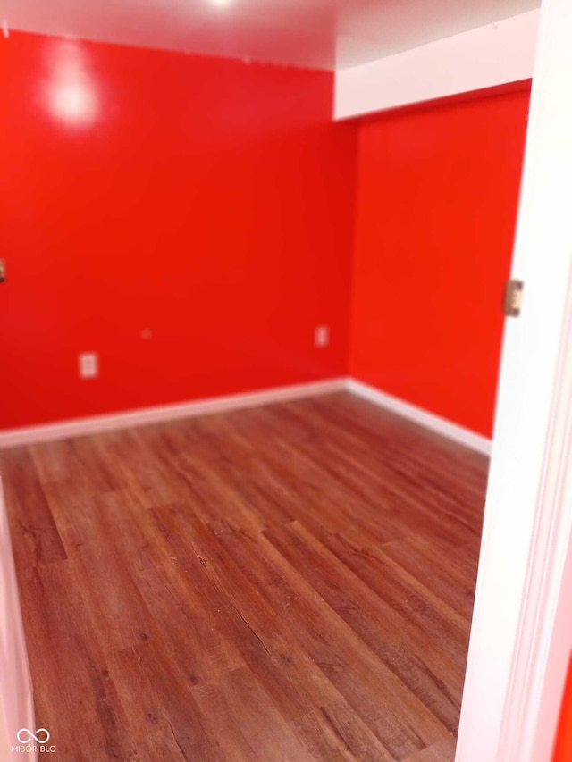 unfurnished room with baseboards and wood finished floors