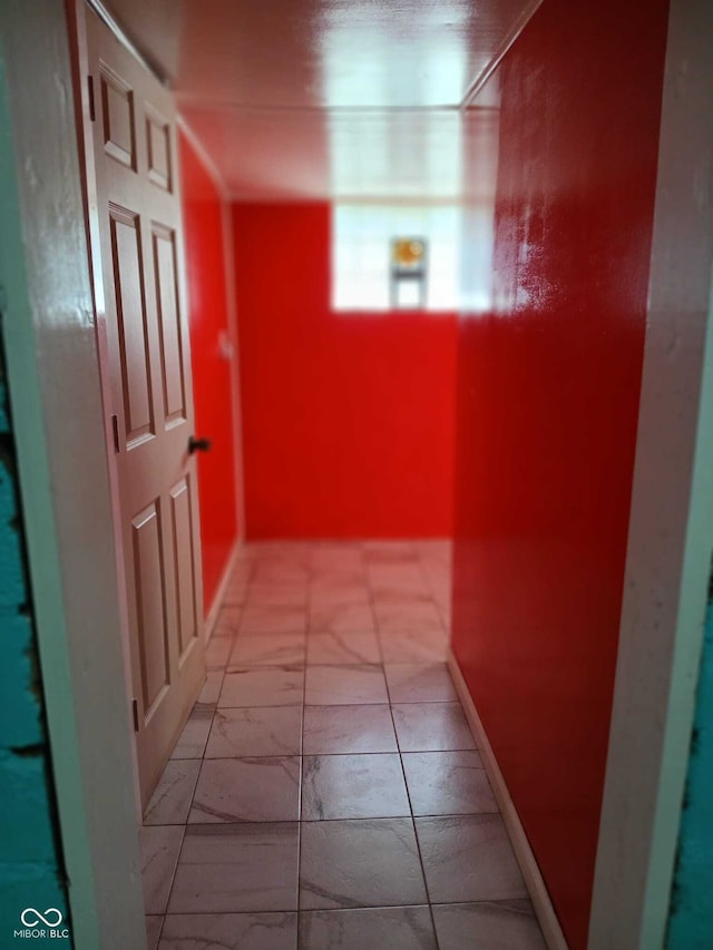 hallway with baseboards and marble finish floor