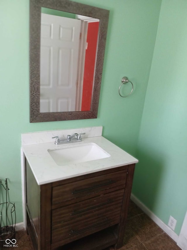 bathroom featuring baseboards, tile patterned flooring, and vanity