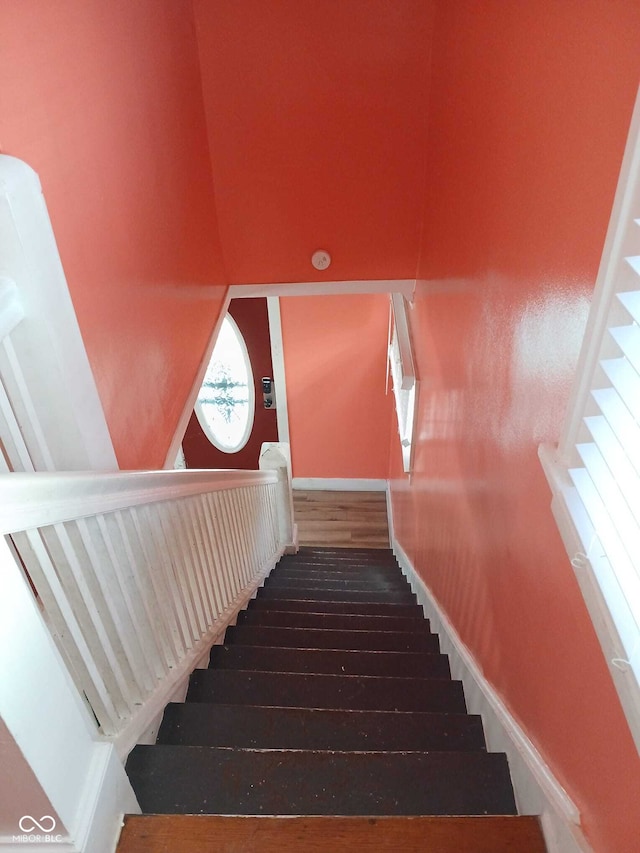 staircase with baseboards and wood finished floors