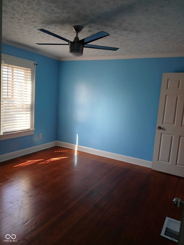 unfurnished room featuring baseboards, a textured ceiling, visible vents, a ceiling fan, and wood finished floors