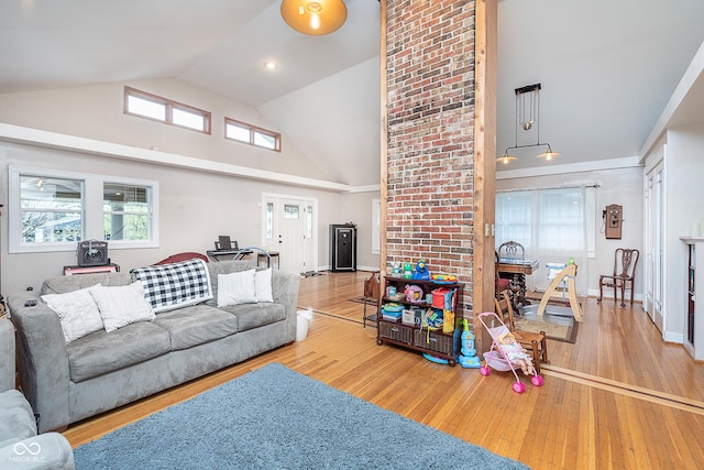 living area with hardwood / wood-style flooring, baseboards, and high vaulted ceiling
