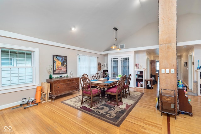 dining room featuring visible vents, baseboards, high vaulted ceiling, and light wood-style floors