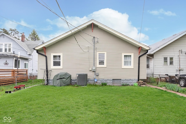 back of property featuring fence, a lawn, and cooling unit