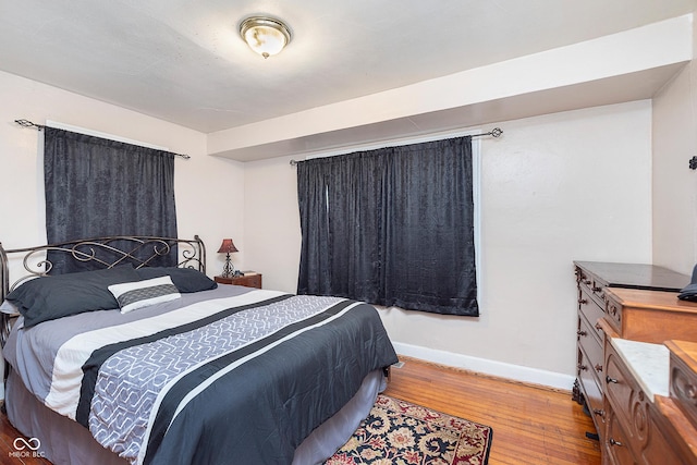 bedroom featuring hardwood / wood-style flooring and baseboards
