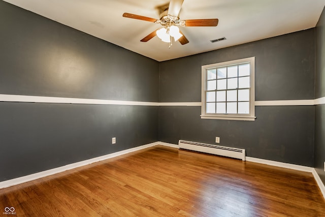 7859 N Chester Ave, Indianapolis, IN 46240 - spare room with baseboard heating, wood finished floors, a ceiling fan, and baseboards
