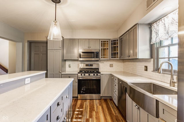 7859 N Chester Ave, Indianapolis, IN 46240 - kitchen featuring appliances with stainless steel finishes, a sink, gray cabinets, dark wood-type flooring, and glass insert cabinets