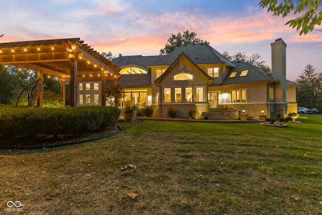 10821 Club Point Dr, Fishers, IN 46037 - rear view of house featuring a chimney, stucco siding, stone siding, and a yard