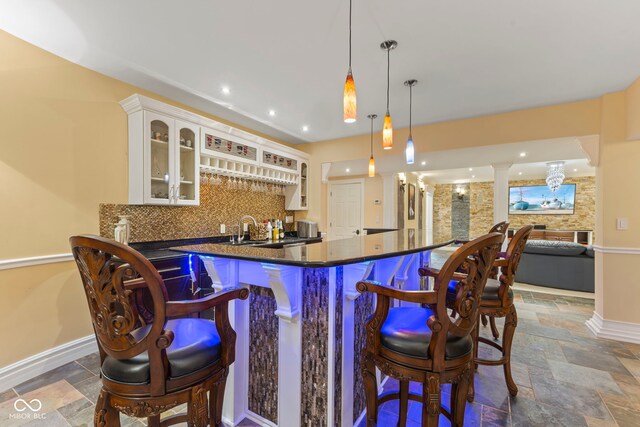 10821 Club Point Dr, Fishers, IN 46037 - bar with wet bar, stone tile floors, baseboards, decorative backsplash, and ornate columns