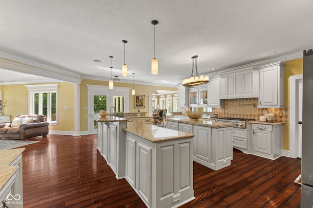 10821 Club Point Dr, Fishers, IN 46037 - kitchen with stainless steel gas stovetop, decorative backsplash, white cabinetry, and a large island with sink