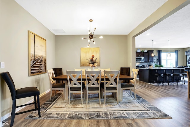 1684 Beach St, Greenwood, IN 46143 - dining area with baseboards, a notable chandelier, visible vents, and wood finished floors