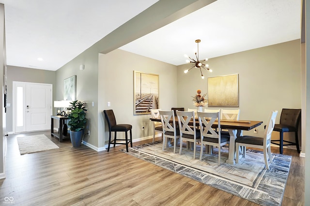 1684 Beach St, Greenwood, IN 46143 - dining room with baseboards, wood finished floors, and an inviting chandelier