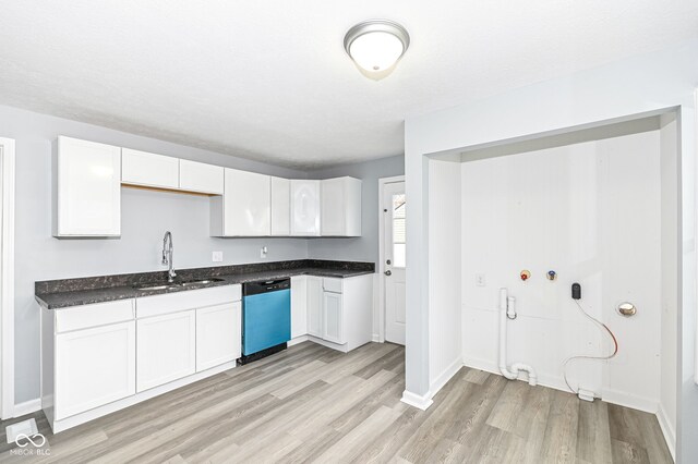 kitchen featuring baseboards, dishwasher, light wood-style floors, white cabinetry, and a sink