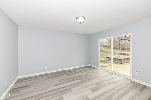 empty room with light wood-style flooring and baseboards