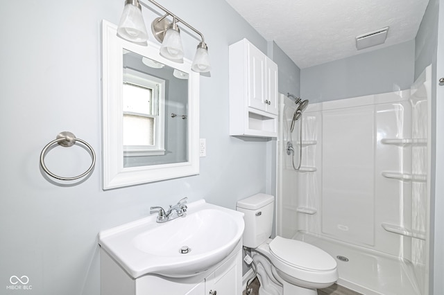 bathroom with visible vents, toilet, a textured ceiling, a shower, and vanity